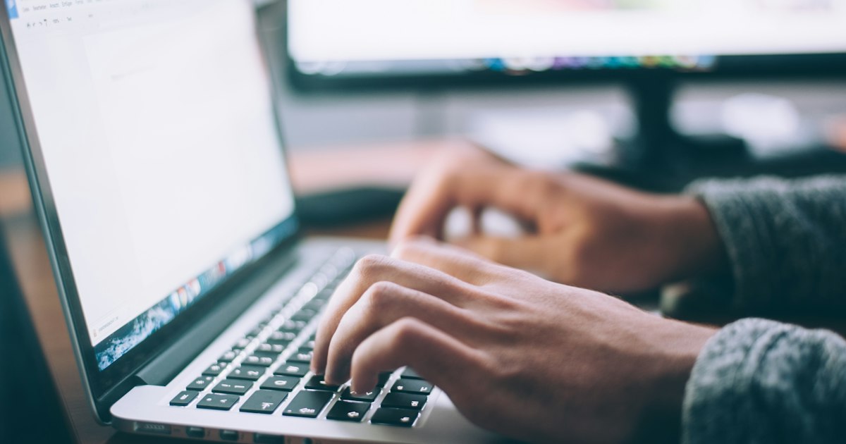 Systems administrator typing Linux terminal commands on keyboard